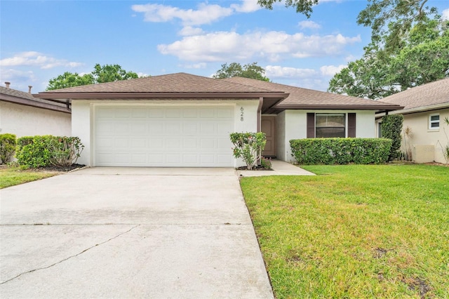 ranch-style house featuring driveway, roof with shingles, a front yard, an attached garage, and stucco siding