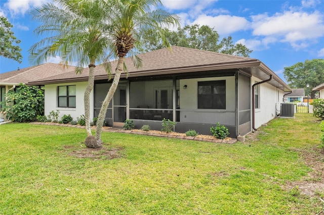 view of front of property with central AC, a sunroom, and a front lawn