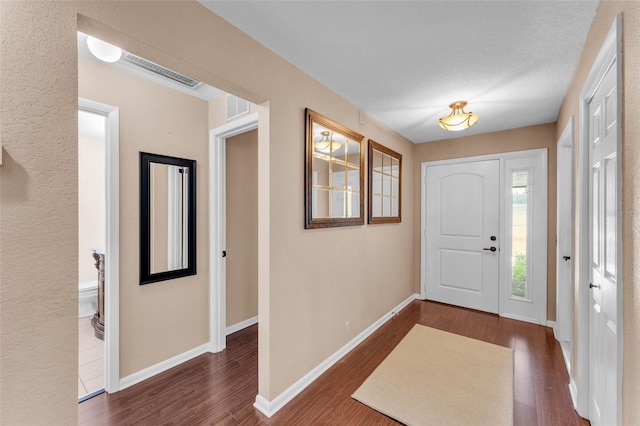 entrance foyer with baseboards, dark wood finished floors, and visible vents
