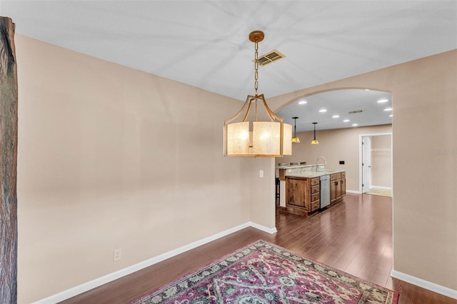 dining space with arched walkways, recessed lighting, baseboards, visible vents, and dark wood-style floors