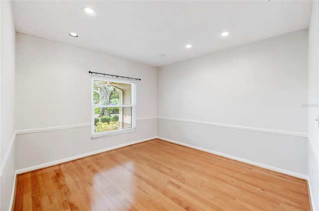 empty room featuring baseboards, wood finished floors, and recessed lighting