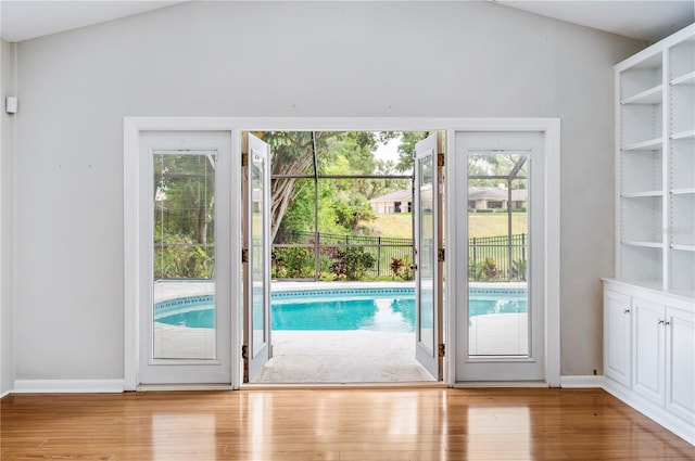 doorway with wood finished floors and baseboards