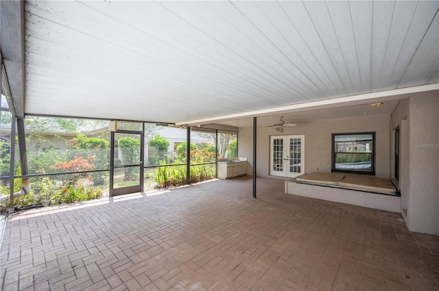unfurnished sunroom featuring french doors and a ceiling fan
