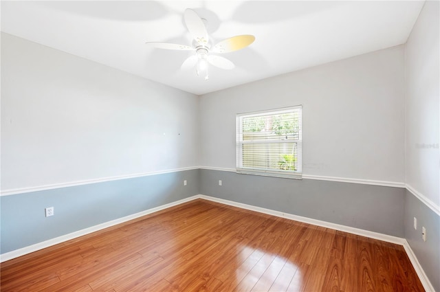 unfurnished room with wood finished floors, baseboards, and a ceiling fan