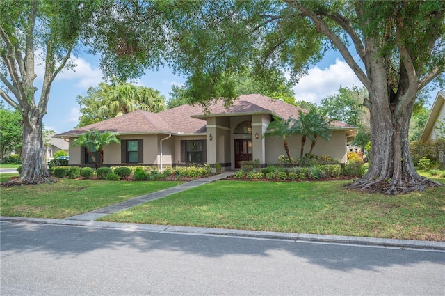 view of front facade with stucco siding and a front yard