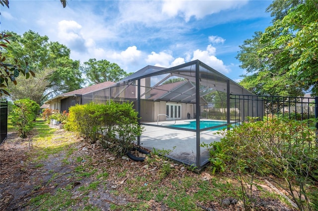 view of pool featuring french doors, glass enclosure, and a patio