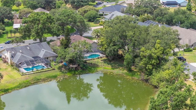 aerial perspective of suburban area featuring a pool area and a nearby body of water