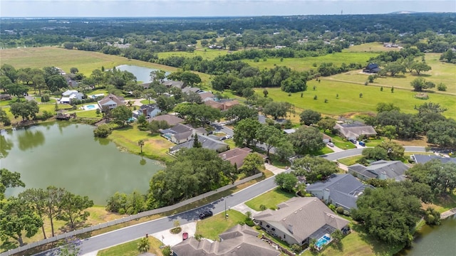 aerial view of property and surrounding area featuring a large body of water and nearby suburban area