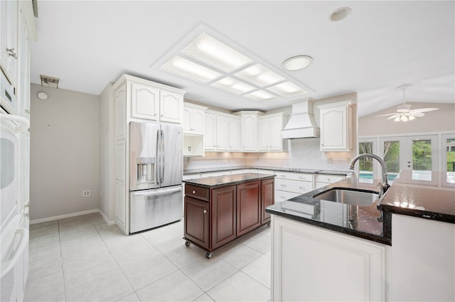 1104 Kells Ct, Lakeland, FL 33813 - kitchen with stainless steel fridge with ice dispenser, a sink, custom range hood, backsplash, and dark stone counters