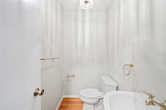 1104 Kells Ct, Lakeland, FL 33813 - bathroom with toilet, wood finished floors, a sink, and baseboards