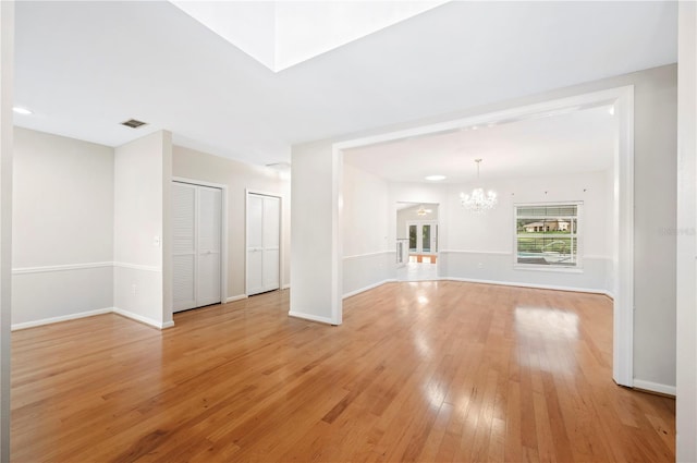1104 Kells Ct, Lakeland, FL 33813 - unfurnished living room with a chandelier, light wood-style flooring, and baseboards