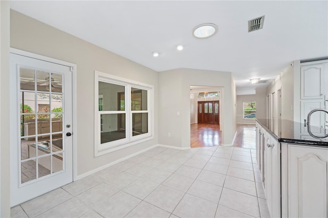 1104 Kells Ct, Lakeland, FL 33813 - kitchen with light tile patterned floors, dark stone counters, baseboards, white cabinetry, and recessed lighting