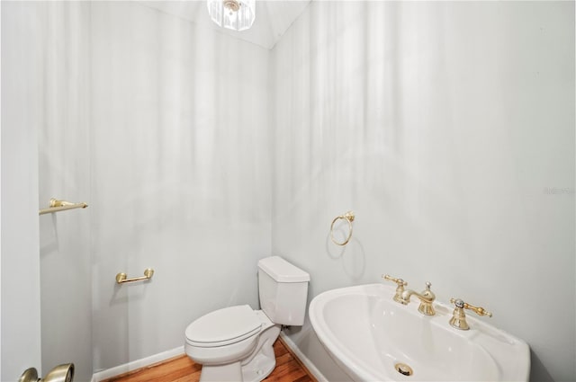 1104 Kells Ct, Lakeland, FL 33813 - bathroom with toilet, a sink, wood finished floors, and baseboards