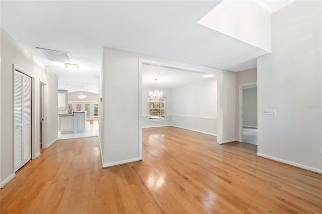 1104 Kells Ct, Lakeland, FL 33813 - unfurnished living room featuring light wood-type flooring, a chandelier, and baseboards