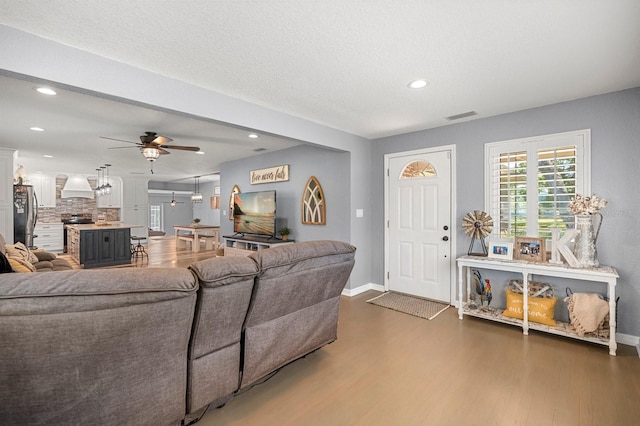 living room with recessed lighting, wood finished floors, visible vents, and ceiling fan
