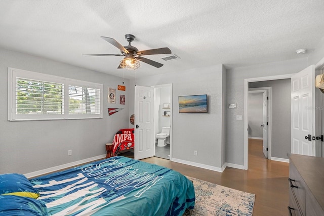 bedroom with wood finished floors, a textured ceiling, and visible vents