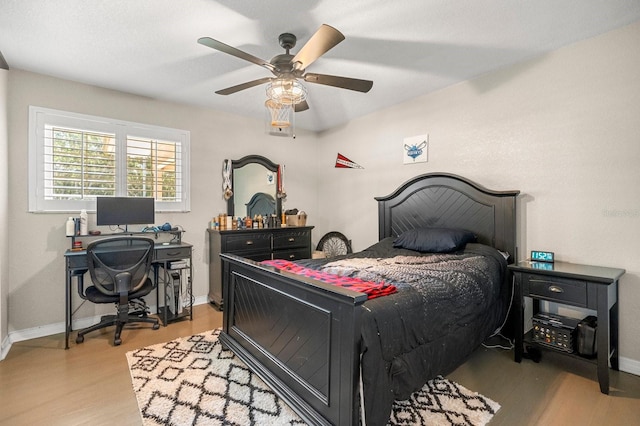 bedroom featuring ceiling fan, baseboards, and light wood-type flooring