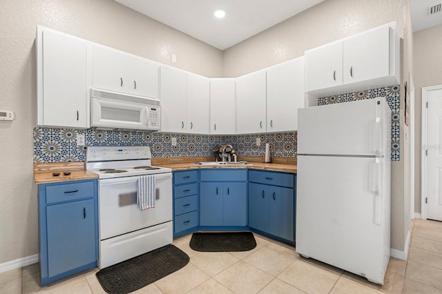 kitchen featuring blue cabinets, white appliances, a sink, and backsplash