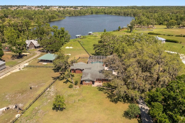birds eye view of property featuring a forest view and a water view