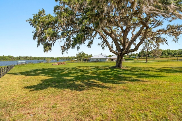 view of yard featuring a water view and fence