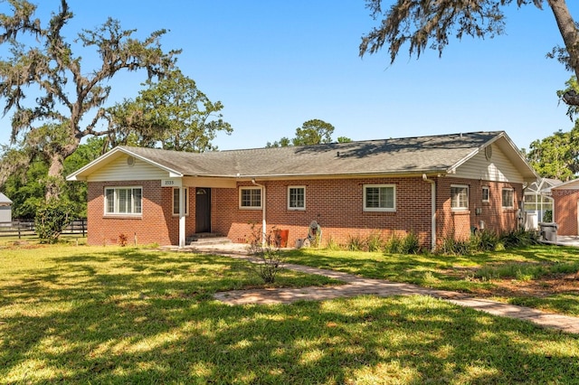 view of front of house with brick siding, fence, and a front yard
