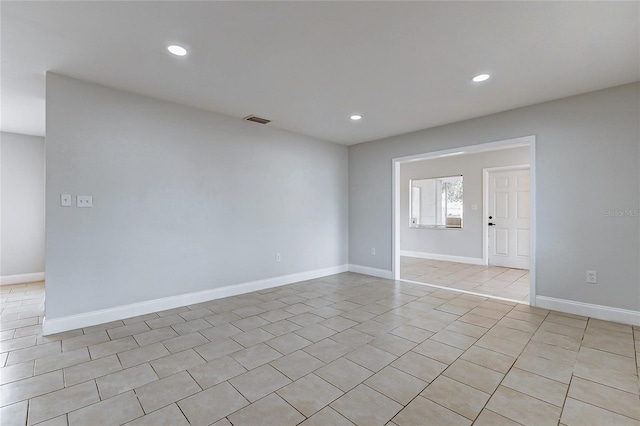 empty room with light tile patterned floors, baseboards, visible vents, and recessed lighting