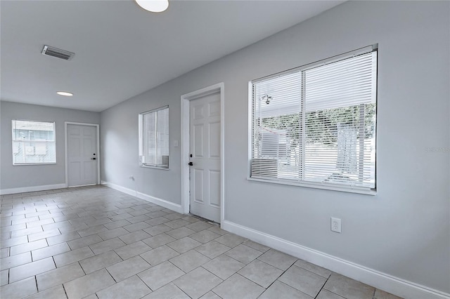 entrance foyer featuring baseboards, light tile patterned flooring, and visible vents