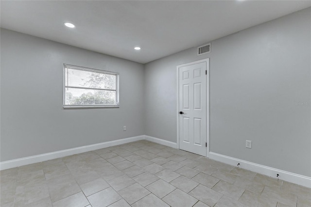 spare room featuring light tile patterned floors, baseboards, visible vents, and recessed lighting