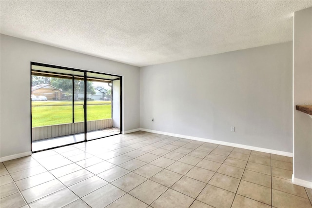 spare room with baseboards, a textured ceiling, and light tile patterned flooring