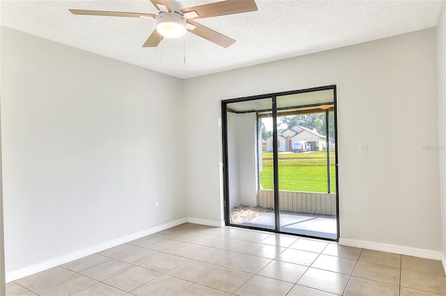 unfurnished room featuring a ceiling fan, baseboards, light tile patterned flooring, and a textured ceiling