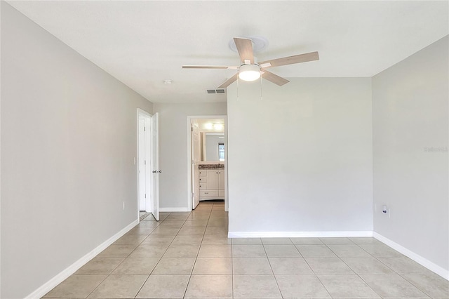 spare room featuring visible vents, baseboards, ceiling fan, and light tile patterned floors