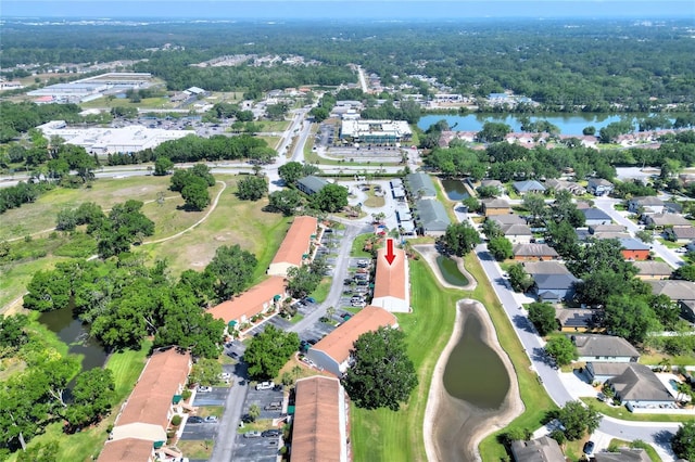 birds eye view of property featuring a forest view and a water view