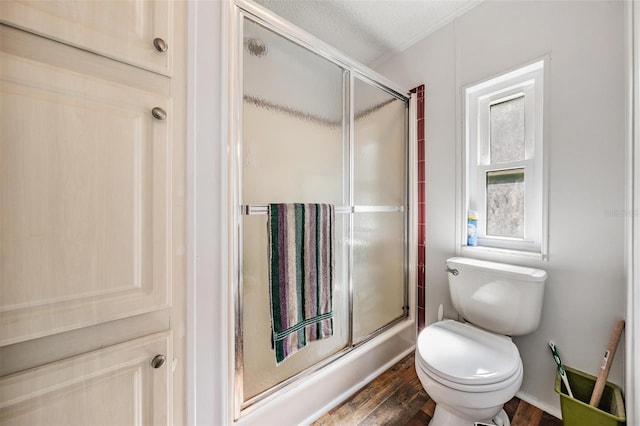 full bathroom with an enclosed shower, toilet, and wood finished floors