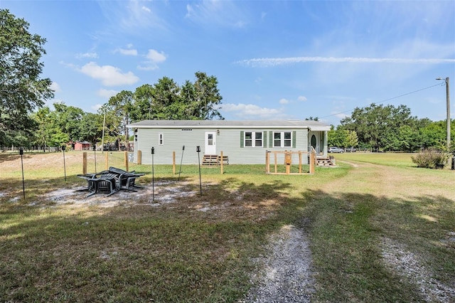 back of property featuring fence and a yard