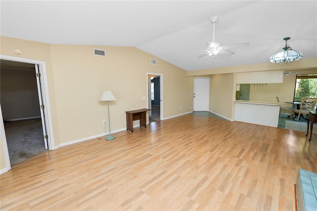 unfurnished living room featuring light wood-type flooring, baseboards, visible vents, lofted ceiling, and a ceiling fan