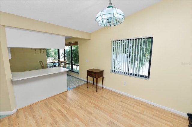 interior space with baseboards, a notable chandelier, and wood finished floors