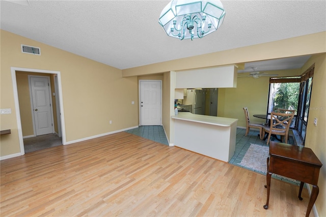 interior space with wood finished floors, visible vents, and a textured ceiling