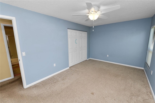 unfurnished bedroom featuring baseboards, carpet, and a closet