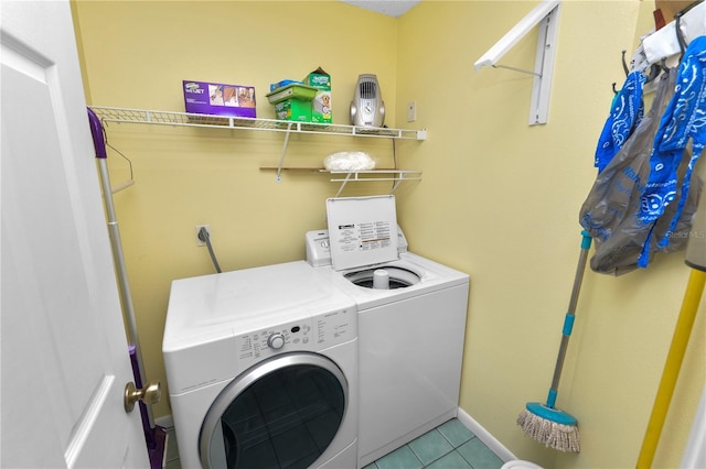 clothes washing area with tile patterned floors, washer and dryer, and laundry area