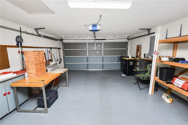 garage with concrete block wall, a workshop area, and a garage door opener