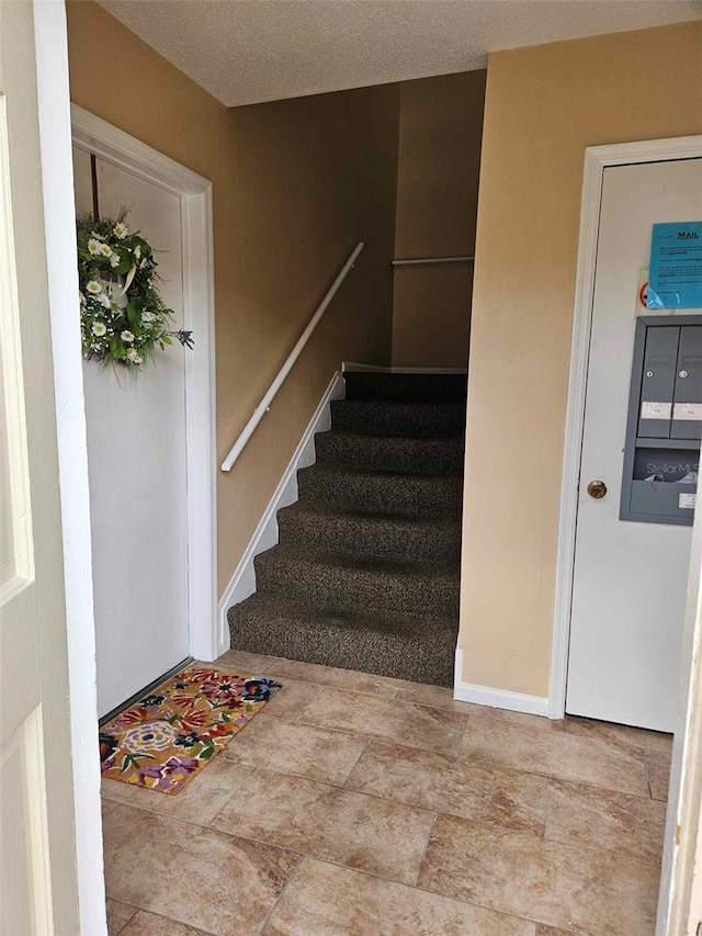 stairway featuring baseboards and stone finish flooring