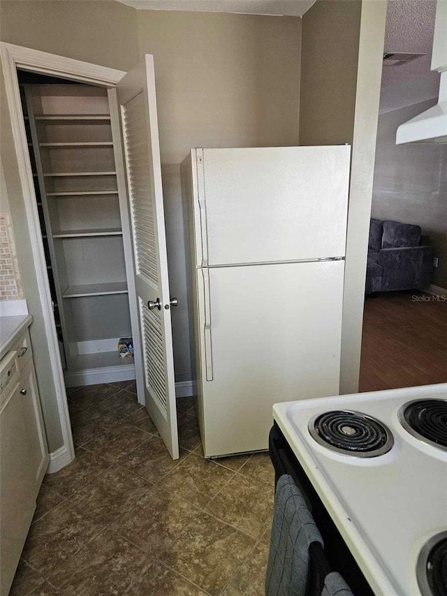 kitchen with white appliances, wall chimney exhaust hood, and light countertops