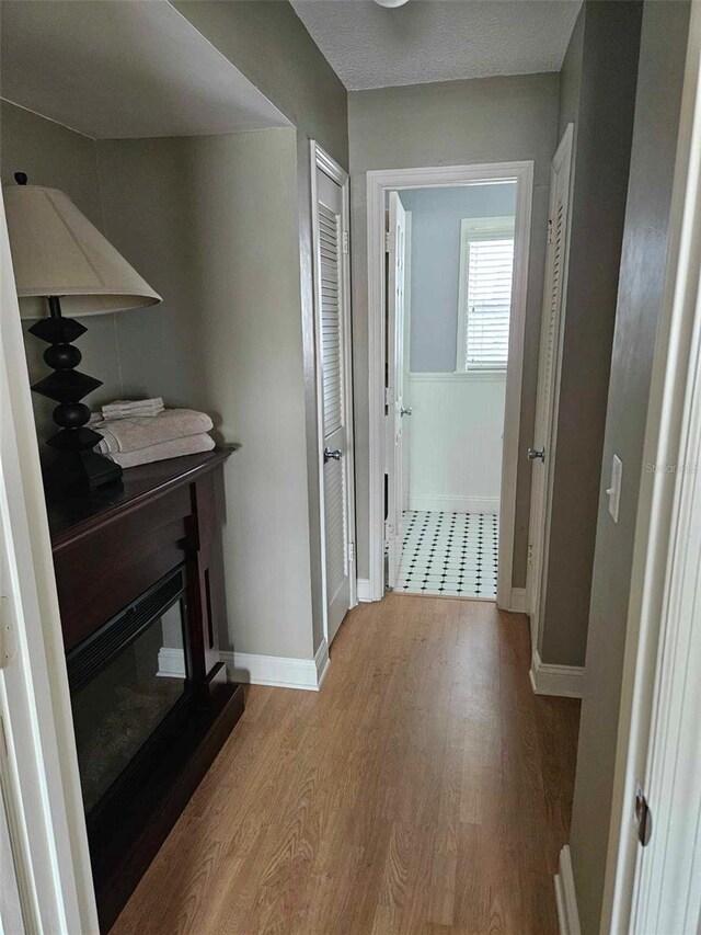 hallway with light wood-style floors and baseboards
