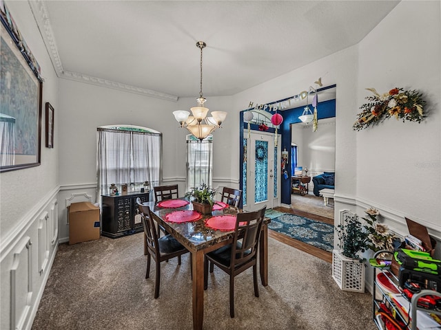 2033 Normandy Heights Dr, Winter Haven, FL 33880 - dining space featuring a chandelier, a wainscoted wall, carpet floors, and a decorative wall