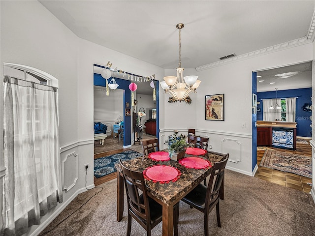 2033 Normandy Heights Dr, Winter Haven, FL 33880 - dining room featuring a chandelier, carpet floors, and a wainscoted wall