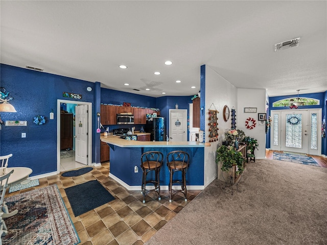 2033 Normandy Heights Dr, Winter Haven, FL 33880 - kitchen with black appliances, light countertops, a kitchen breakfast bar, recessed lighting, and a peninsula