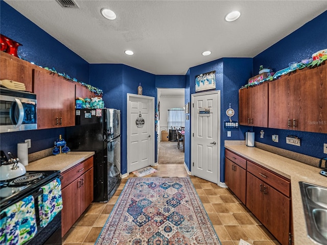 2033 Normandy Heights Dr, Winter Haven, FL 33880 - kitchen with black appliances, light countertops, recessed lighting, a textured wall, and a sink