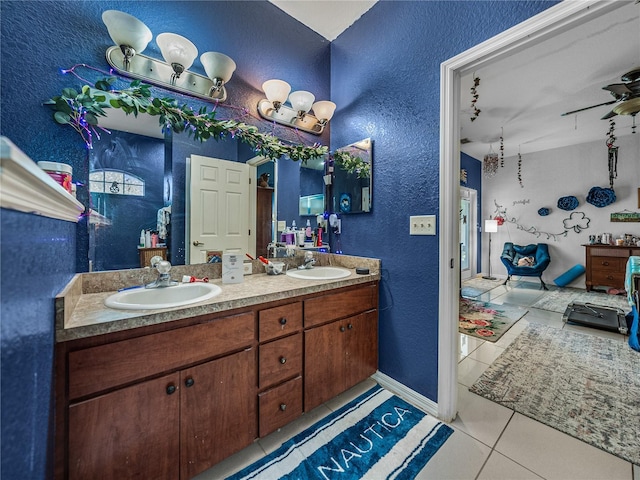 2033 Normandy Heights Dr, Winter Haven, FL 33880 - bathroom featuring a textured wall, tile patterned floors, double vanity, and ceiling fan