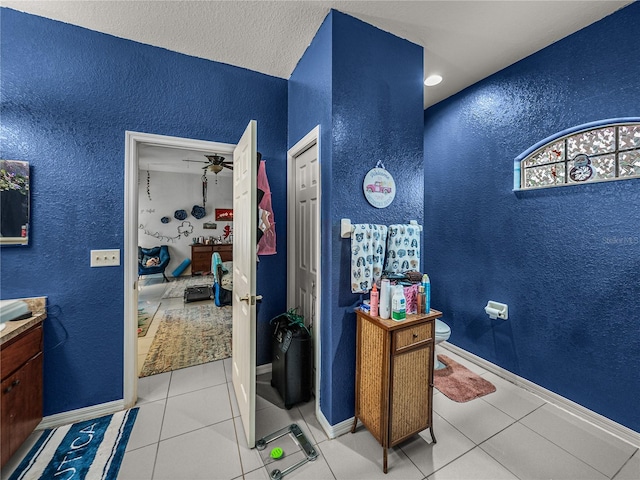 2033 Normandy Heights Dr, Winter Haven, FL 33880 - ensuite bathroom with a textured wall, vanity, tile patterned flooring, a ceiling fan, and toilet