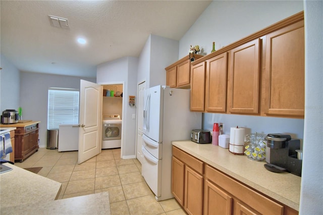 3684 Madbury Cir, Lakeland, FL 33810 - kitchen featuring light tile patterned floors, washer / dryer, light countertops, visible vents, and freestanding refrigerator